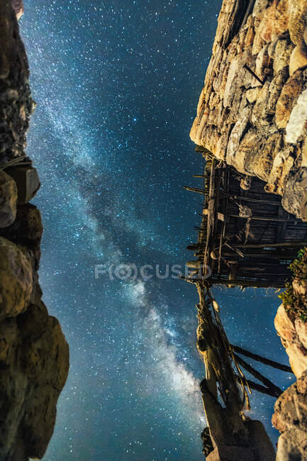 From below stone walls of aged building located against starry sky in Cala D'Hort at night on Ibiza, Spain — Stock Photo