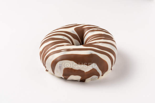 Donuts glaseados enteros de chocolate dulce sabroso apilados sobre fondo blanco - foto de stock