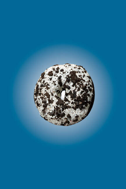 White and black sweet chocolate doughnut floating on blue background — Stock Photo