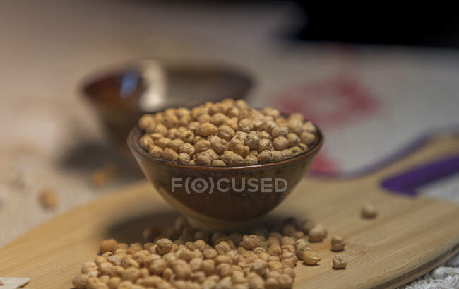 Pile of raw chickpea placed on lumber board in kitchen — Stock Photo