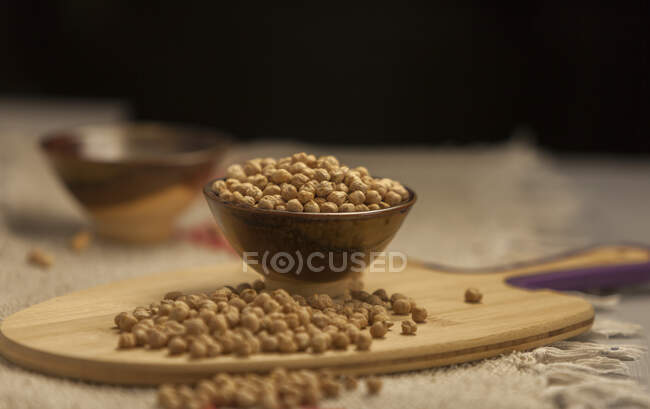 Pile of raw chickpea placed on lumber board in kitchen — Stock Photo