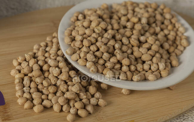 Top view of pile of raw chickpea placed on lumber board in kitchen — Stock Photo