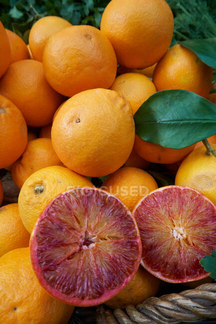 Dall'alto metà di arancione rosso messo su mucchio di agrumi in cesto sul mercato — Foto stock