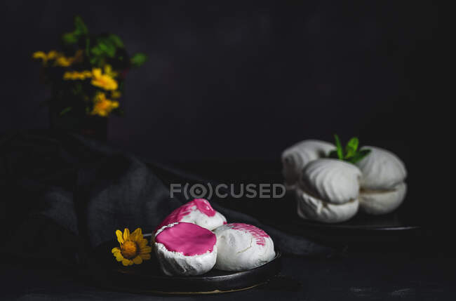 Von oben hausgemachter weißer Zefir oder Zephyr, traditionelles russisches Dessert mit Minze und Erdbeersirup, auf schwarzem Hintergrund — Stockfoto