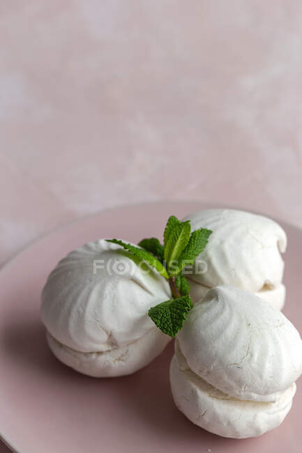 Homemade white Zefir traditional russian dessert with mint on pink background — Stock Photo