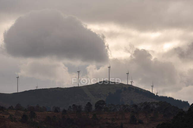 Ветряные мельницы современной ветряной электростанции расположены на холме в сельской местности — стоковое фото