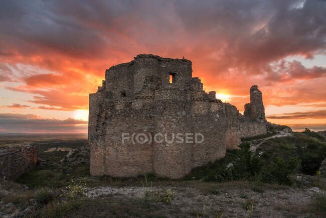 Visitando o castelo medieval arruinado contra o céu nublado do pôr-do-sol no campo em Toledo — Fotografia de Stock