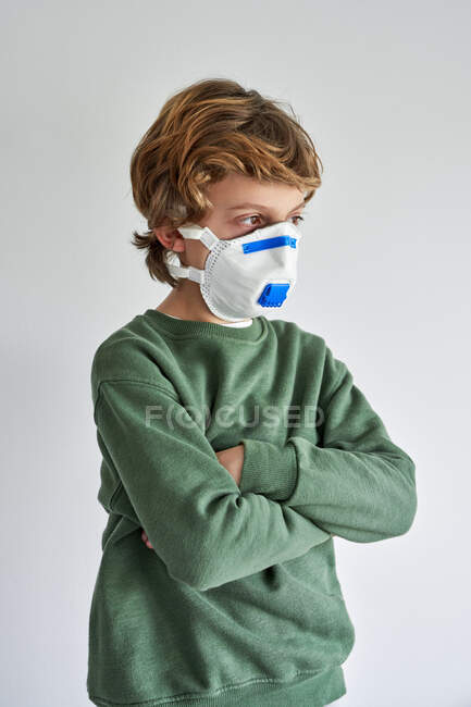 Блондин, около 8 лет, носит респиратор, чтобы заразить себя вирусом. — стоковое фото
