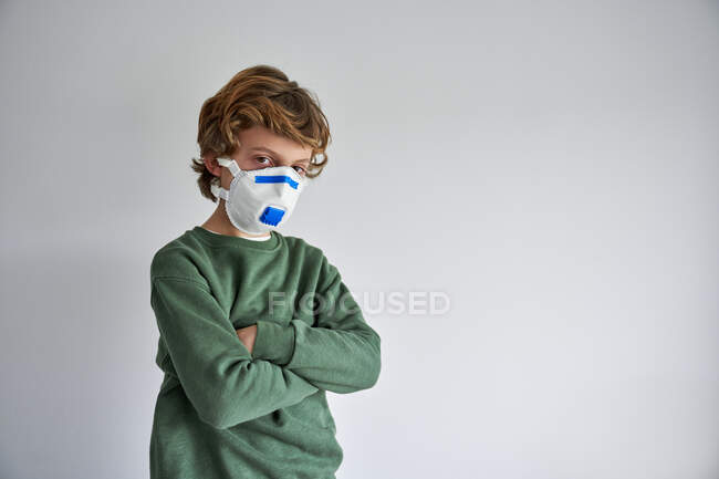 Хлопчик-блондин, якому близько 8 років, одягнений у респіратор, щоб співзаразити себе вірусом. — стокове фото
