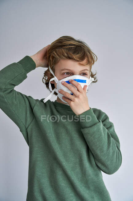 Garçon blond, environ 8 ans, portant un respirateur pour se co-infecter avec un virus — Photo de stock