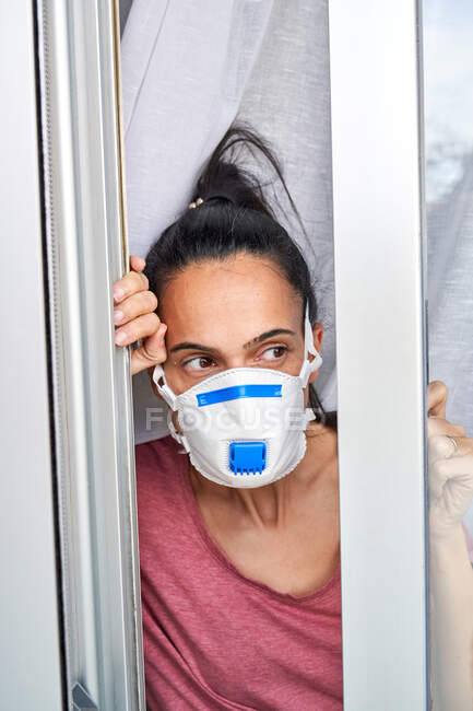 Mother and child looking out their home window to see if the danger of possible infection has passed — Stock Photo