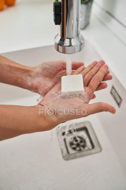 Donna che si lava le mani sul lavello della cucina per evitare possibili infezioni — Foto stock