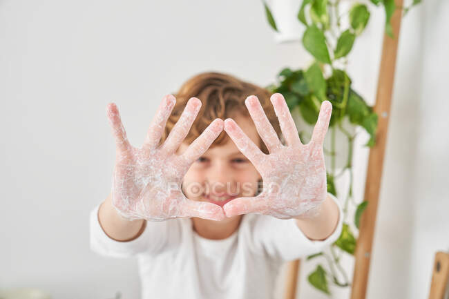 Enfant blond se lavant les mains dans l'évier de la cuisine pour éviter toute infection — Photo de stock