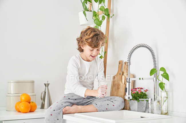 Blondes Kind wäscht sich die Hände in der Spüle, um Infektionen vorzubeugen — Stockfoto
