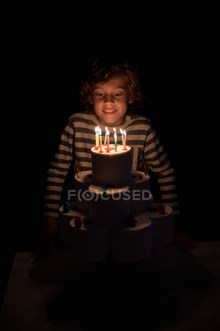 Blonder Junge bläst die Kerzen auf seinem Toilettenpapier-Geburtstagskuchen aus — Stockfoto
