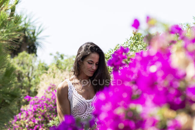Giovane bella donna a piedi in un giardino — Foto stock