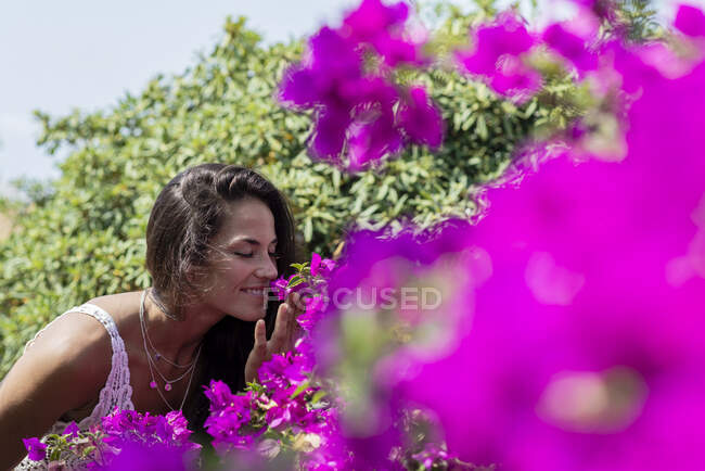 Giovane bella donna odora di fiore in giardino — Foto stock