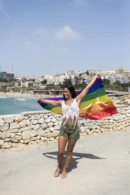 Portrait of a pretty hispanic woman playing with a lgtb flag — Stock Photo