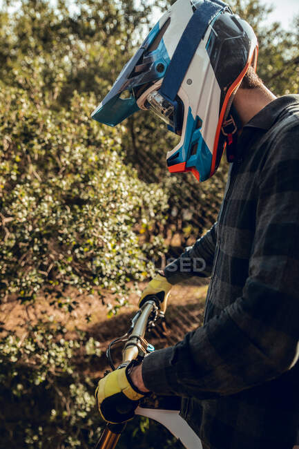 Desportista de bicicleta de montanha irreconhecível em pé no topo da colina na floresta — Fotografia de Stock