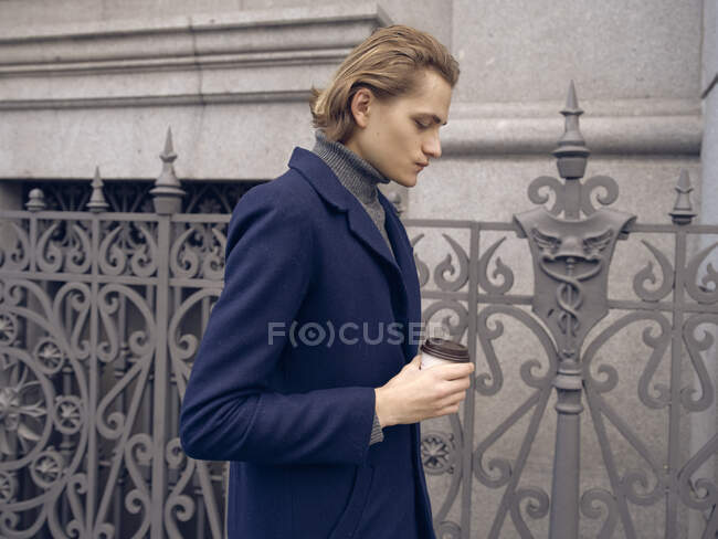 Красивый стильный мужчина с кофе в городе — стоковое фото