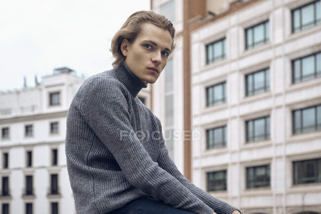 Moderno sério jovem macho com corte de cabelo elegante em camisola quente cinza — Fotografia de Stock