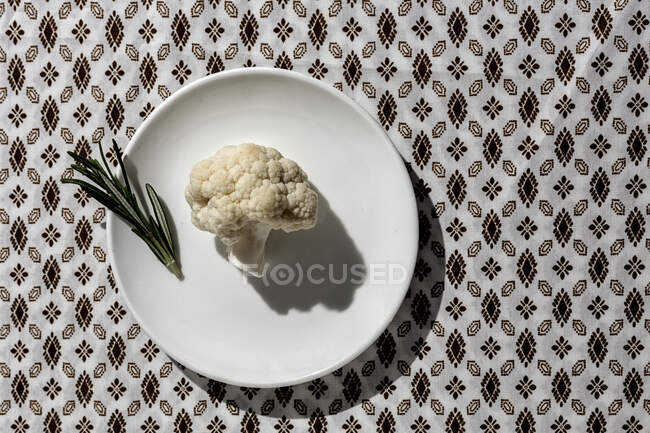 Raw cauliflower bouquet with rosemary from above with sunlight. Flat lay. Top view — Stock Photo