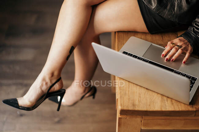 Перекручений образ підприємця в ретро-одязі, який сидить на столі і переглядає ноутбук під час роботи в офісі — стокове фото