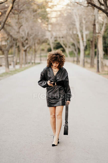 Empreendedor feminino de corpo inteiro em roupa vintage andando no asfalto — Fotografia de Stock