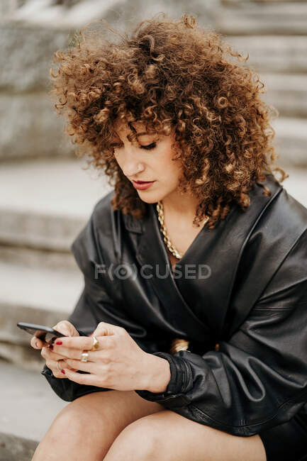 Mujer de negocios retro usando smartphone en escaleras - foto de stock