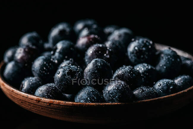 Bleuets frais sur un bol en bois sur la table — Photo de stock