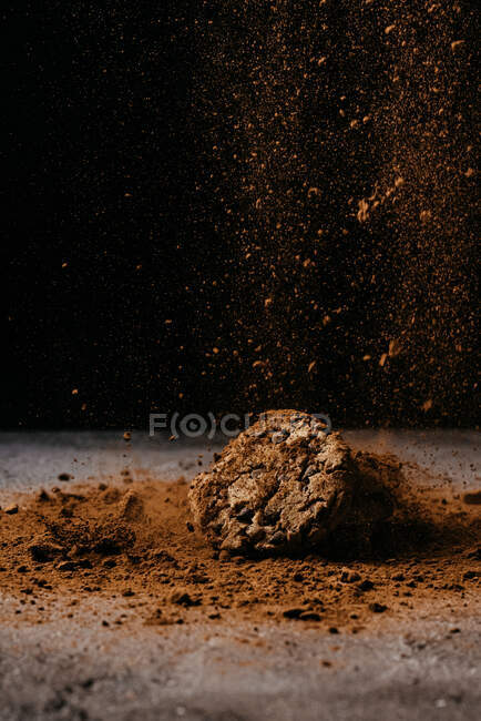 Galleta sobre mesa con cacao en polvo espolvoreada - foto de stock