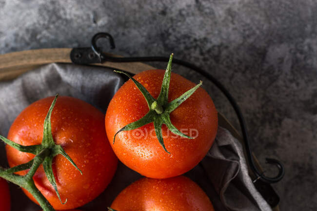 From above of wet clean tomatoes placed on gray fabric napkin on grey concrete table background — Stock Photo