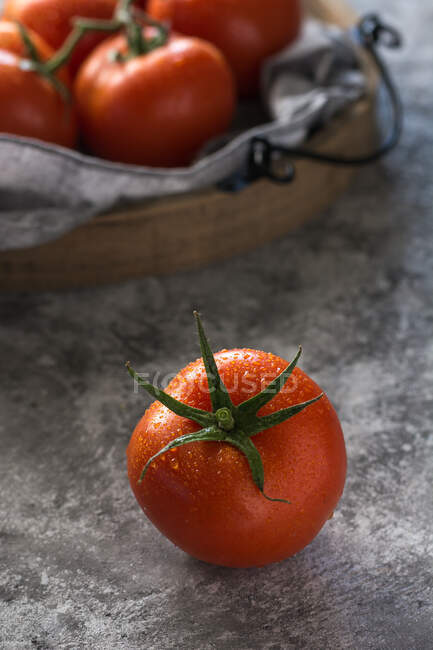Von oben nass saubere Tomaten auf graue Stoffserviette auf grauem Betontischhintergrund gelegt — Stockfoto