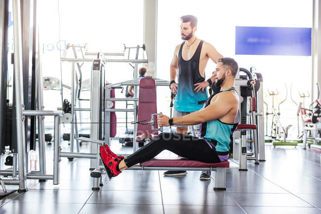 Atleta muscular adulto fazendo exercício no ginásio — Fotografia de Stock
