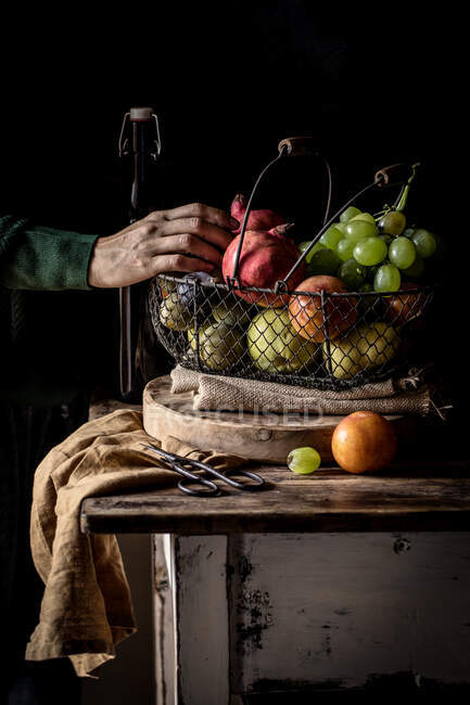 Cultivo persona mayor que toma fruta de la cesta - foto de stock