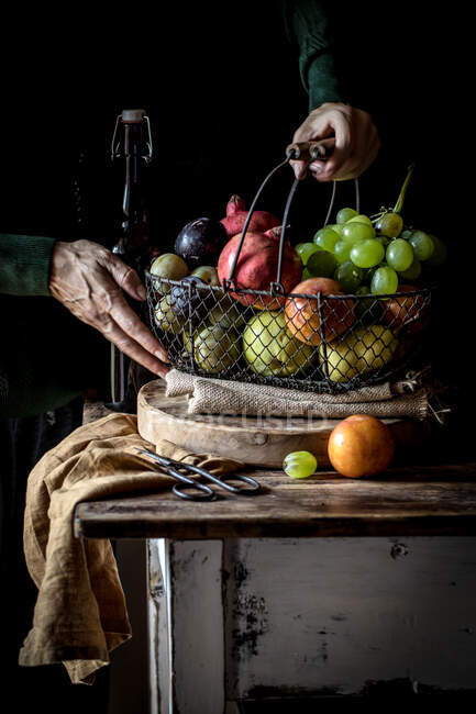 Старший урожай берет фрукты из корзины — стоковое фото