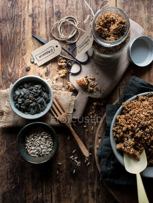 From above yummy millet and quinoa granola and fresh seeds placed on lumber table in kitchen — Stock Photo