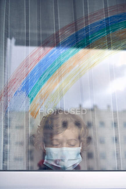 Мальчик за окном во время карантина — стоковое фото