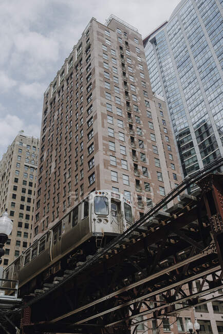 Train on elevated road near modern buildings — Stock Photo