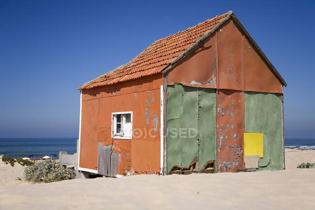 Маленький будинок на березі моря з блакитним небом — стокове фото