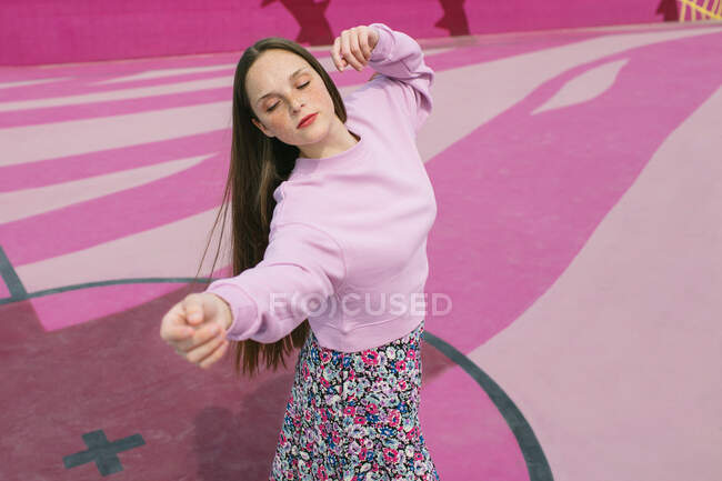 Elegante mujer joven en patines posando en el patio de recreo - foto de stock