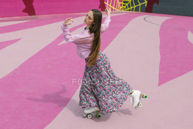 Jeune femme élégante sur patins à roulettes posant sur une aire de jeux — Photo de stock