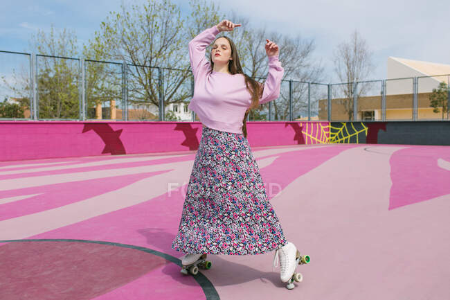 Stilvolle junge Frau auf Rollschuhen posiert auf Spielplatz — Stockfoto