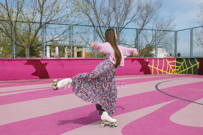 Jovem elegante em patins posando no playground — Fotografia de Stock