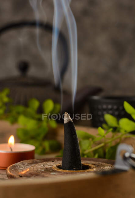 Zusammensetzung brennender Räucherkegel, Teekanne und Kerzen — Stockfoto