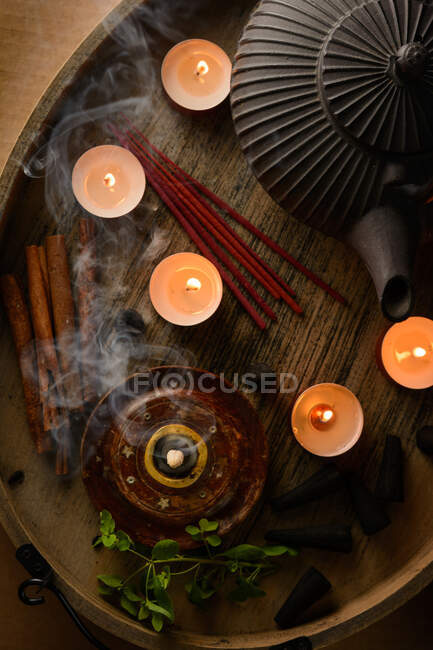 Composición de cono de incienso ardiente, tetera y velas - foto de stock