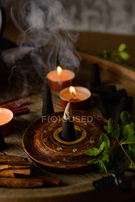 Composition of burning incense cone and candles — Stock Photo