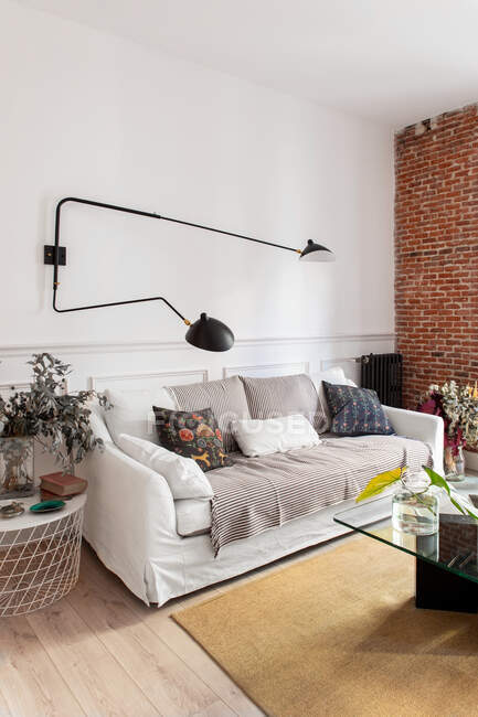 Уютный интерьер гостиной с диваном и кирпичной стеной — стоковое фото