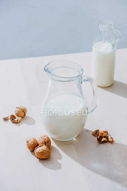 Frasco de leite e nozes na mesa — Fotografia de Stock
