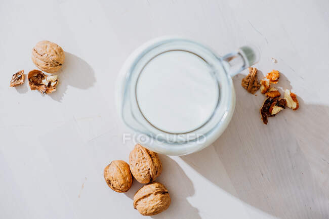 Jar of milk and nuts on table — Stock Photo